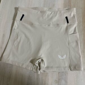 Castore women's athletic shorts in a light beige color